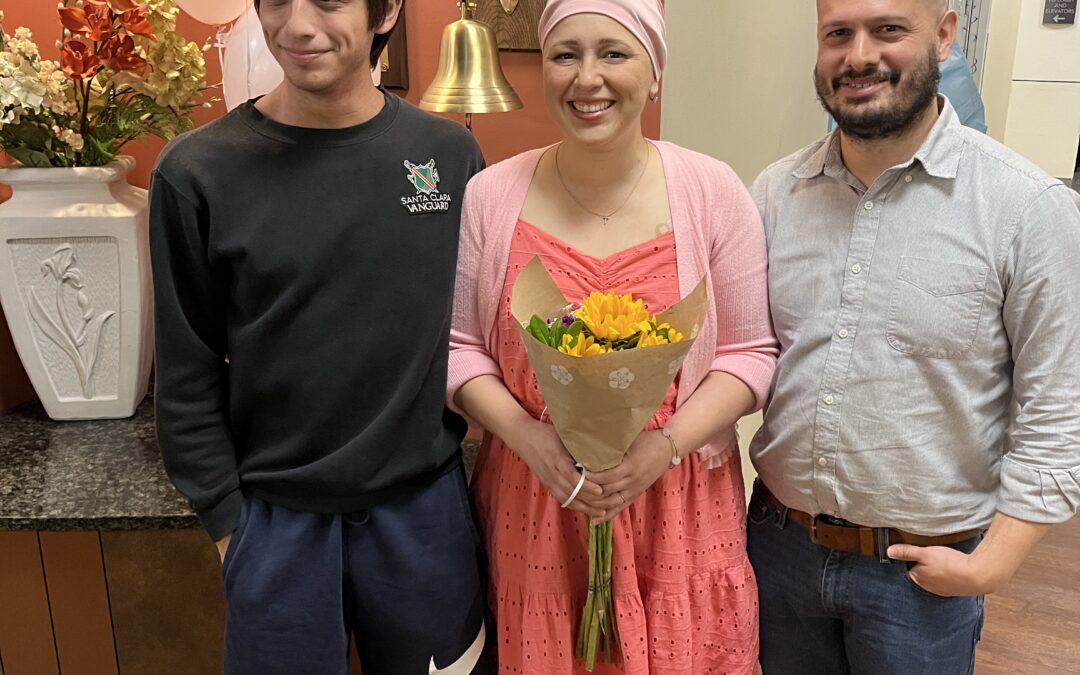 Mom, Dad and Schuyler posing in front of the chemotherapy bell.